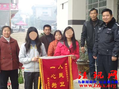 图为被解救的两名湖北少女及家人送锦旗感谢黔江民警;摄影:邹鹏